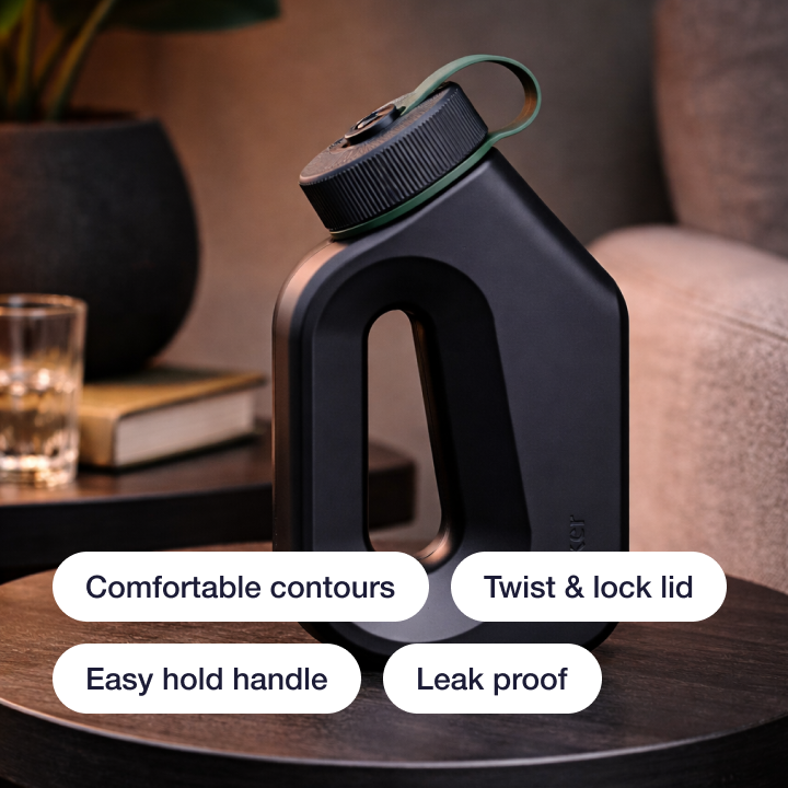 Black Tanker male urinal on a wooden side table with feature labels: comfortable contours, twist & lock lid, easy hold handle, and leak proof